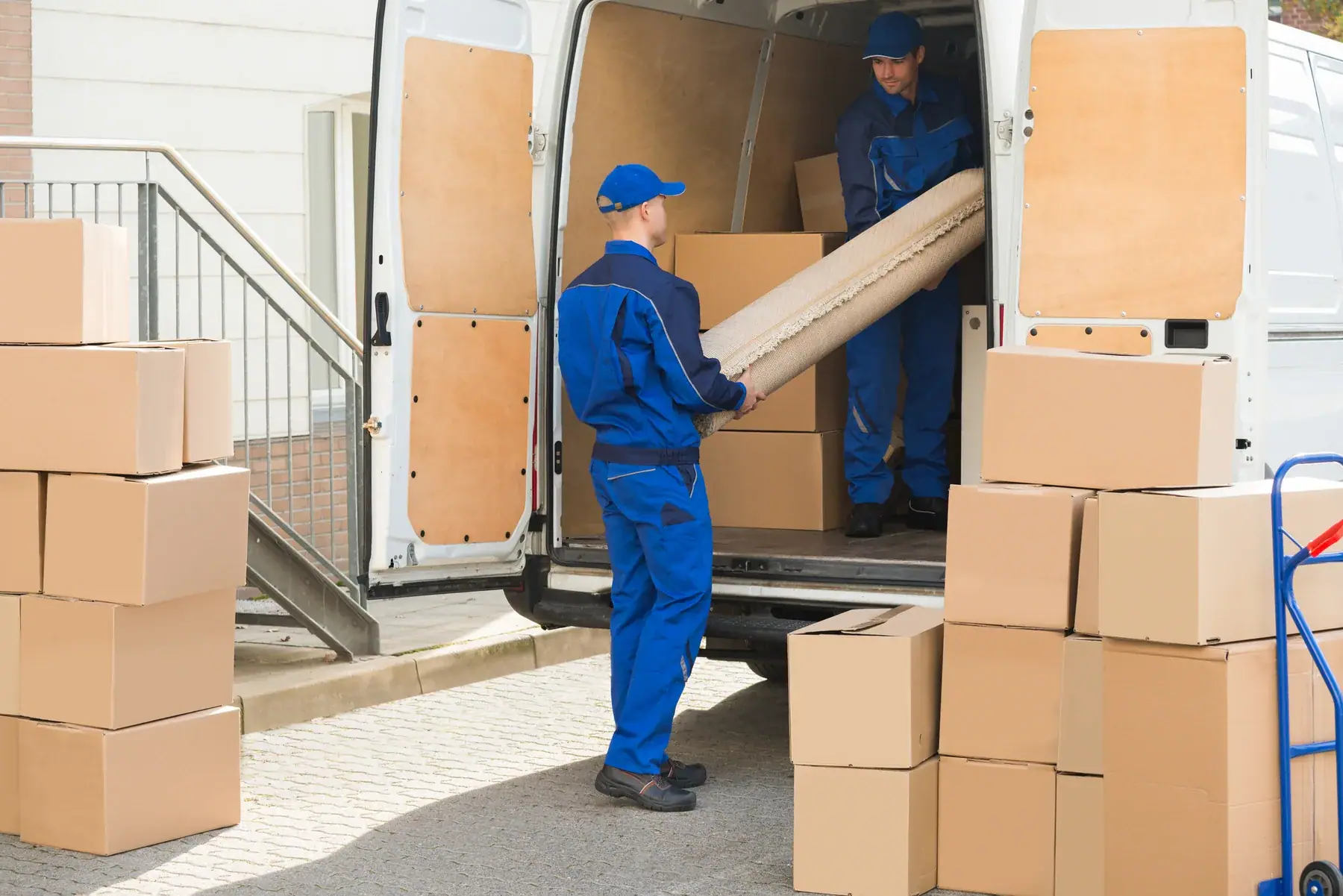 Möbelpacker beladen einen Transporter mit Kartons für einen Firmenumzug